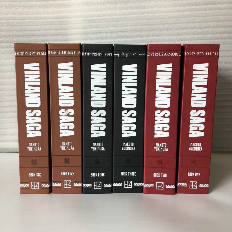 Six Vinland Saga Deluxe hardcover volumes standing spine-out, Book One through Book Six